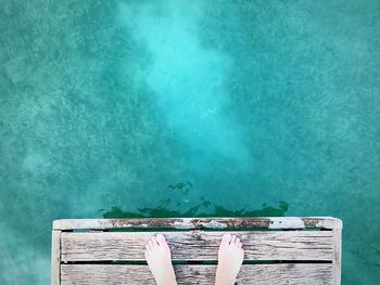 Low section of woman relaxing in swimming pool