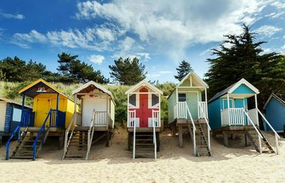 Row of wooden cottages on sandy beach