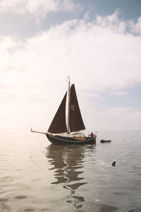 Sailboat sailing on sea against sky