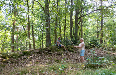 Full length of young woman standing in forest