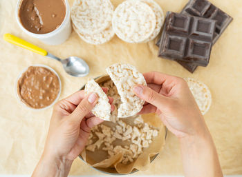 Top view of the process of preparing a delicious dessert peanut butter along with rice cakes. 