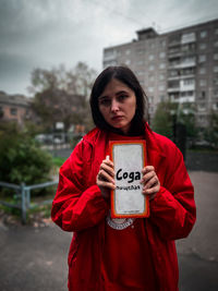 Portrait of young woman holding text