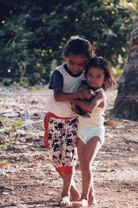 Full length of siblings walking on field