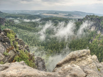 Foggy and cloudy evening on the sandstone view point in national park.