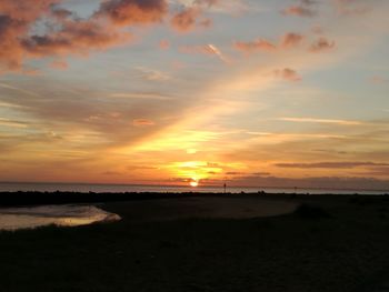 Scenic view of beach against sky during sunset