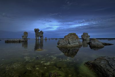 Rocks on sea shore against sky