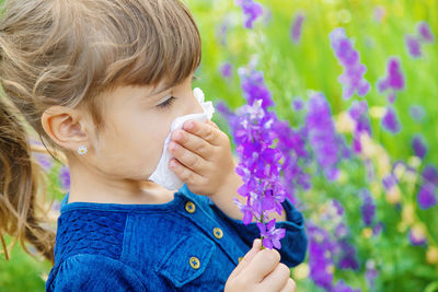 Close-up of girl blowing flowers