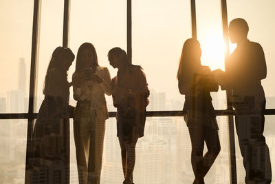 Silhouette business people standing by window at office