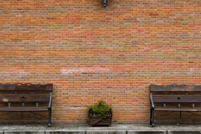 Empty benches against brick wall