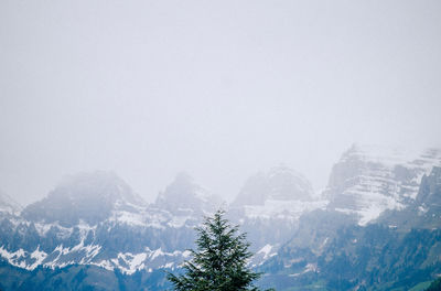 Scenic view of snow covered mountains against clear sky