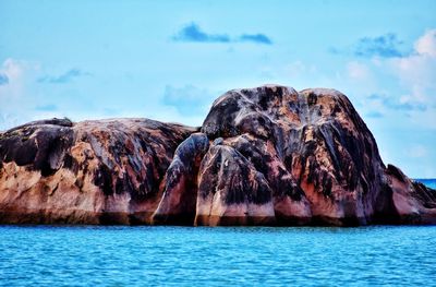 Rock formation in sea against sky