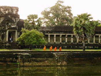 View of temple by building against sky