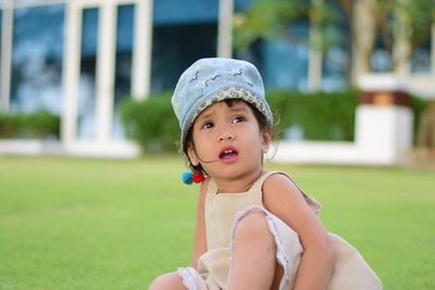 Girl looking up while sitting at park
