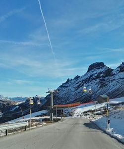 Road by mountains against blue sky