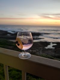 Close-up of water on table against sea during sunset