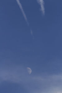 Low angle view of moon against blue sky