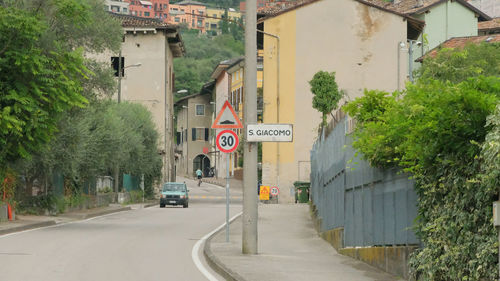 Road sign by building in city