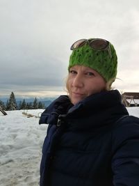 Portrait of smiling woman in snow against sky