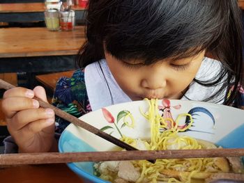 Portrait of cute girl holding food on table