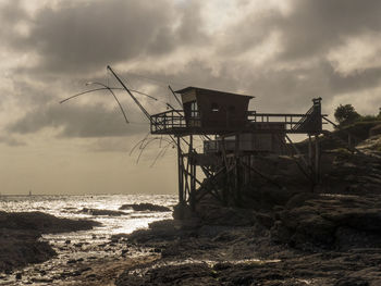 Lifeguard hut on beach against sky