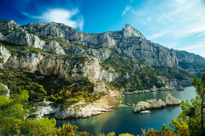 Scenic view of sea and mountains against sky