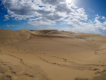 Scenic view of sand dunes against dramatic sky