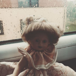 Portrait of cute girl looking through window