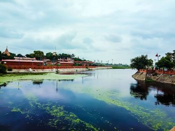 Scenic view of lake and buildings against sky