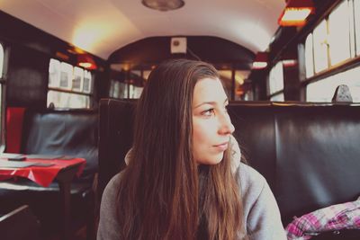 Woman looking away while sitting in bus