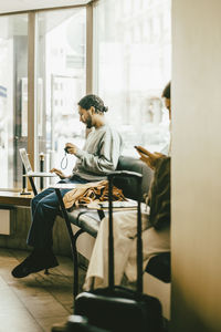 Full length of man using laptop while sitting in restaurant