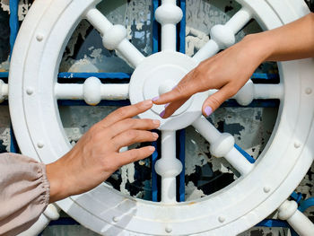 Two female hands stretch each other their index fingers against  symbolic steering wheel