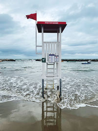 Lifeguard hut at beach against sky