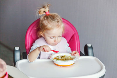 Portrait of cute girl eating food at home