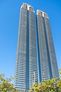 Low angle view of modern buildings against clear blue sky