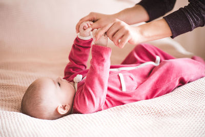 Cropped hands of mother playing with baby at home