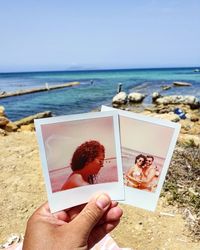 Midsection of woman photographing at beach against clear sky