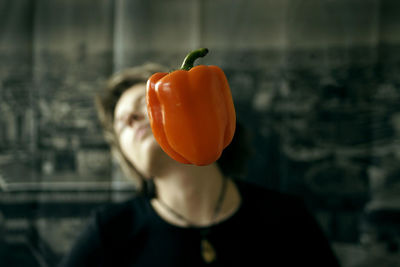 Midsection of woman with red bell peppers