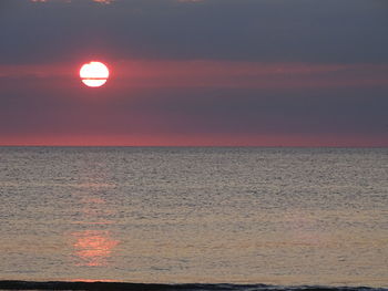 Scenic view of sea against orange sky