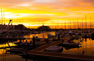 Boats moored at harbor during sunset