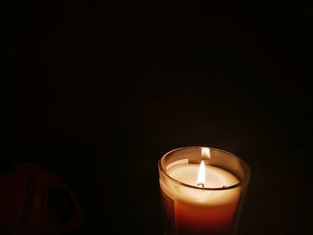 Close-up of illuminated candle against black background