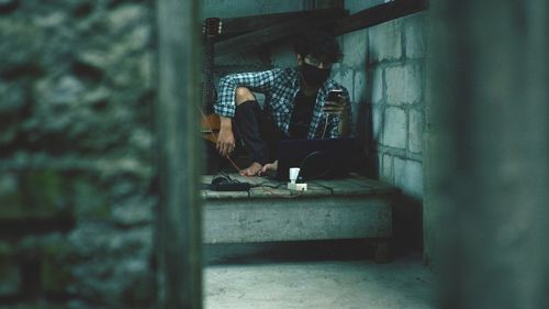 Low section of man sitting on wall