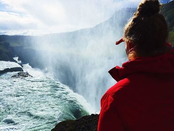 Rear view of man looking at waterfall