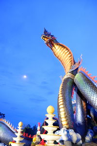 Low angle view of chinese dragon against blue sky