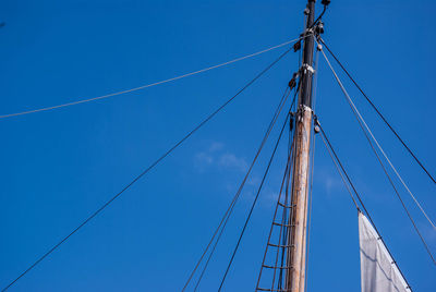 Low angle view of masts against clear blue sky