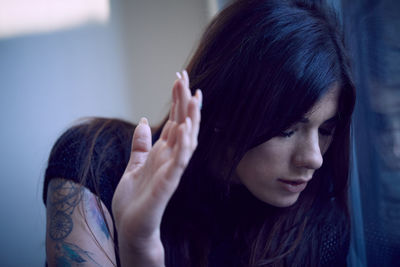 Close-up of worried woman by window