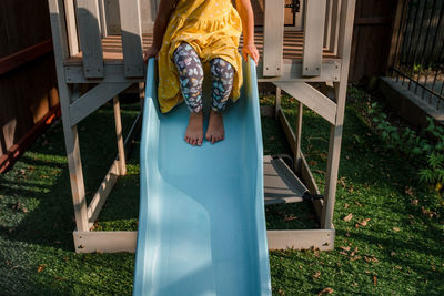 Child sitting at the top of a blue slide