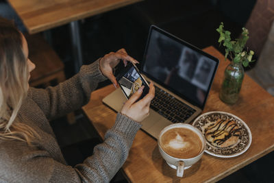 Woman taking photo in cafe