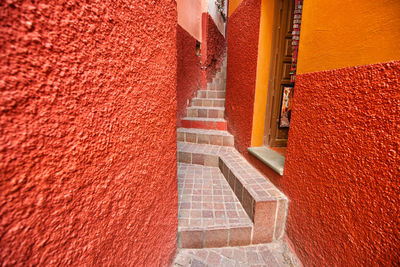 High angle view of steps by red wall