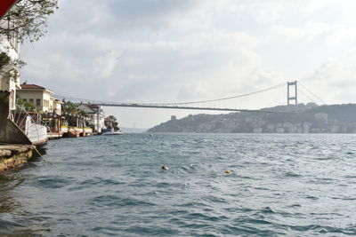 Bridge over sea against sky in city