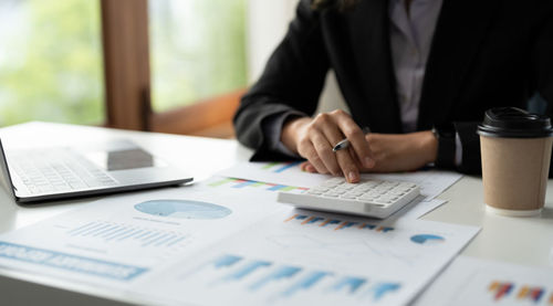 Midsection of business people working on table